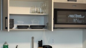 A kitchen with a built-in oven, a sink, and a countertop with a knife block and a toaster. - Executive Studio Near Rogers Place” (Edmonton)