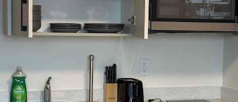 A kitchen with a countertop, a sink, a dish rack, a toaster, and a cabinet with a Maytag oven.