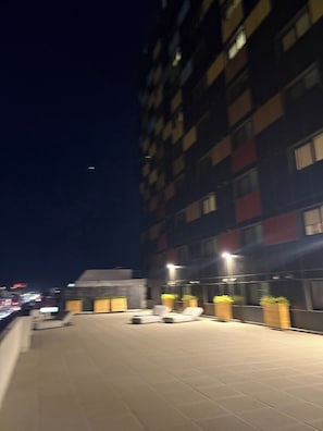 Eine Dachterrasse mit Liegestühlen und Pflanzenkübeln.