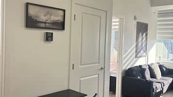 Een kamer met een bureau, stoel en een bank. Er is een deur die naar een andere kamer leidt.