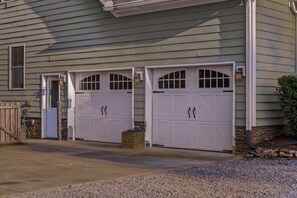 A two-car garage with a stone foundation and a wooden fence. - Cedar Peak - Hot Tub, Sauna, Theater, Sleeps 24 (Cheatham County)