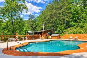 A swimming pool with a wooden deck, lounge chairs, and a small building with a porch. - Ember Hollow | Hot Tub • Near Gatlinburg • Pets (Gatlinburg)