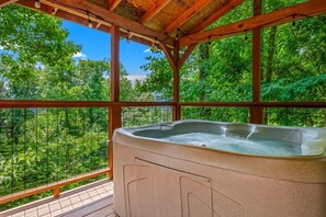 A hot tub under a wooden pergola with a view of a forest. - Ember Hollow | Hot Tub • Near Gatlinburg • Pets (Gatlinburg)