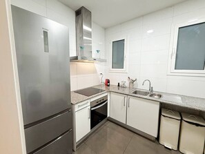 A modern kitchen with stainless steel appliances, a built-in oven, and a double sink. - Nomad friendly • Wi-Fi Fast • Rooftop • Center BCN (Barcelona)