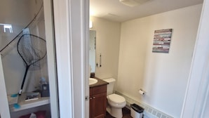 A bathroom with a toilet, sink, and mirror. - Umingmak Lodge Bed And Breakfast (Cambridge Bay)