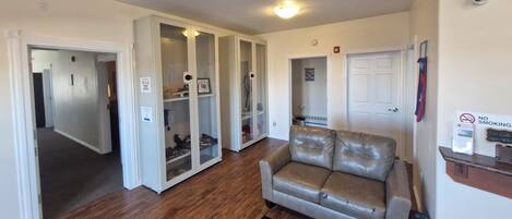 A room with a leather sofa, a wooden floor, and a white door.