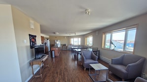 A spacious living area with a kitchen, dining table, and seating. - Umingmak Lodge Bed And Breakfast (Cambridge Bay)