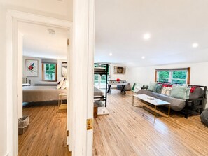 A spacious living area with a sofa, a coffee table, and a dartboard. - Near Killington & Woodstock | Game Room, Fireplace (Bridgewater)