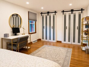 A bedroom with a bed, a desk with a computer, a chair, a desk lamp, a mirror, a wardrobe with sliding doors, and a bookshelf. - Near Killington & Woodstock | Game Room, Fireplace (Bridgewater)