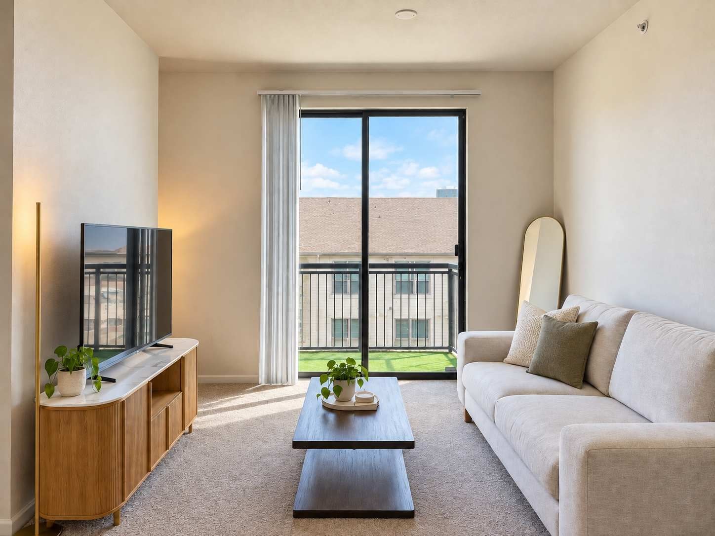 A modern living room with a flat-screen TV, a wooden cabinet, a coffee table, and a sofa.