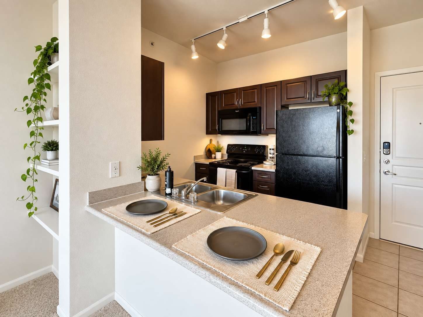 A modern kitchen with a central island, stainless steel appliances, and a white door.
