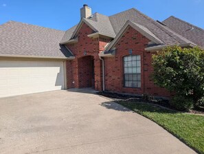 A residential house with a garage, a brick facade, and a large window. - A Relaxing Denton Oasis (Denton)