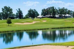 A golf course with a pond, sand bunkers, and trees. - 2-bedroom hotel in perfect Branson with fitness room and AC / 1364m (Branson)
