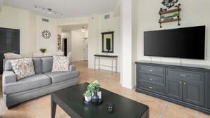 Ein Wohnzimmer mit Sofa, Couchtisch, Fernseher und ein TV-Schrank mit Schubladen.