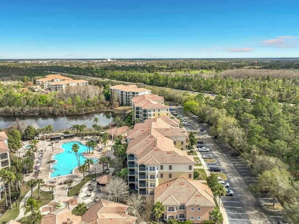 Un resort con varias construcciones, una piscina y un estacionamiento.