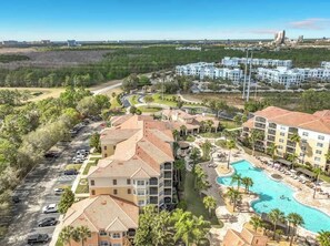 A resort with multiple buildings, a swimming pool, and a parking lot. - Modern Disney Escape, Near the Parks (Orlando)
