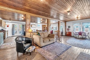 A cozy interior with a wooden ceiling, a sofa, a leather armchair, and a dining area with a table and chairs. - The Country Store at Clemson (Anderson County)