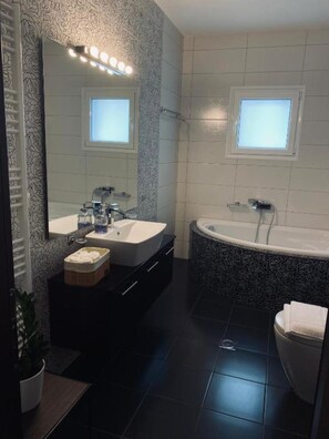 A modern bathroom with a vanity, a bathtub, and a toilet. - 3 bedroom and 2 bathrooms apartment in Anatoli area with AC for relaxing stays (Anatoli)