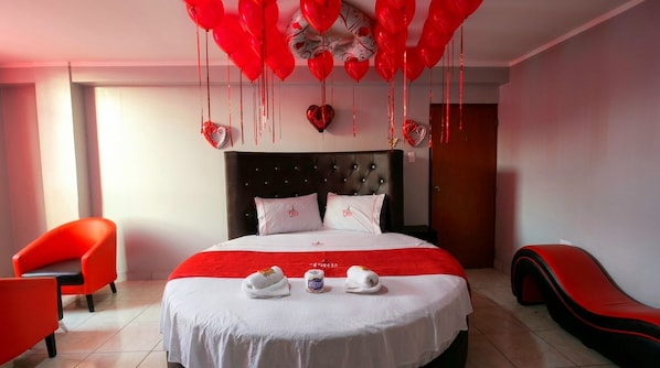A hotel room with a bed, red chairs, and a red sofa. - HOSTAL PARIS 4 (Lima)