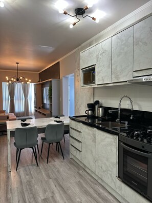 A modern kitchen with a central island, a built-in microwave, and a stove. - Apto Avenida principal Urubici (Urubici)
