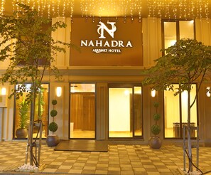 L’extérieur de l’hôtel Nahadra Airport présente une entrée bien dégagée, des plantes en pot et une enseigne au-dessus des portes.