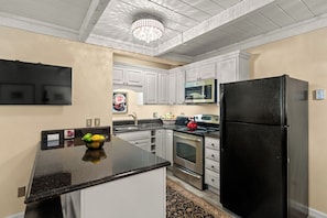 A modern kitchen with a black refrigerator, stainless steel appliances, and a granite countertop. - Sun Valley Atelier Retreat - 5 minute walk to Sun Valley Pavilion (Sun Valley)