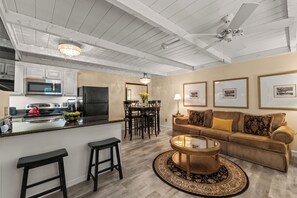 A modern kitchen with a central island, a dining area with a table and chairs, a living room with a sofa and a coffee table, and a ceiling fan. - Sun Valley Atelier Retreat - 5 minute walk to Sun Valley Pavilion (Sun Valley)