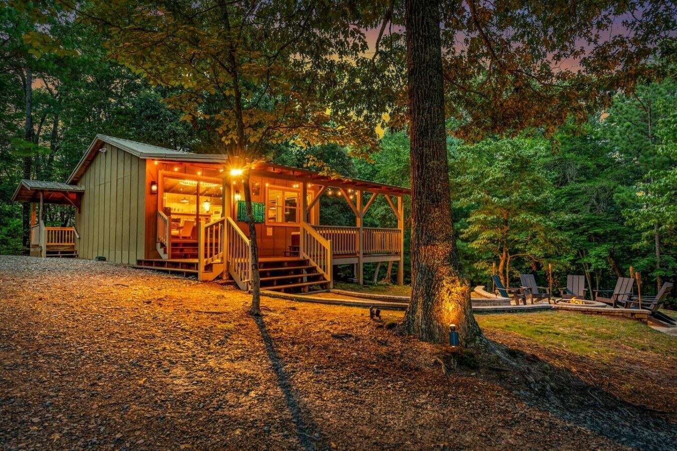 Eine Hütte mit Veranda, Feuerstelle und Sitzgelegenheiten im Freien.