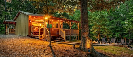 A cabin with a porch, a fire pit, and outdoor seating.