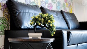 Een zwarte leren bank met een decoratieve muur op de achtergrond.