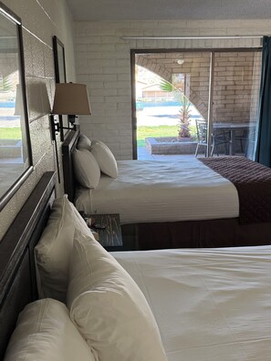 Quarto de hotel com duas camas, uma janela e vista para o exterior.