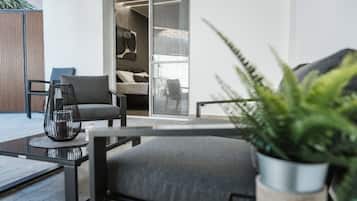 A modern living room with a sofa, a chair, a coffee table, and a potted plant.