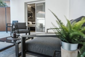 A modern living room with a sofa, a chair, a coffee table, and a potted plant. - Sindis Rooms (Palermo)