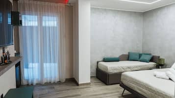A modern hotel room with a bed, a desk, and a TV.