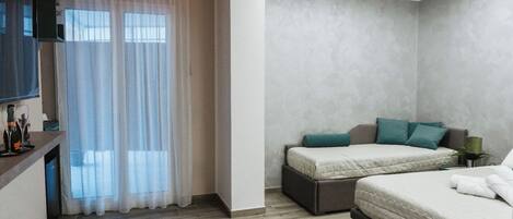 A modern hotel room with a bed, a desk, and a TV.