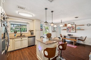 A modern kitchen with a central island, built-in appliances, and pendant lighting. - Clearwater Waterfront Escape w/ Private Pool (Clearwater)