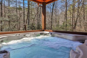 A hot tub with a wooden deck and a view of a forest. - Mountain Escape - Hot Tub, Fire Pit, Games & 3 Scenic Decks (Ellijay)