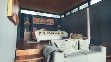 Una sala de estar moderna con un sofá, una cama y una escalera.