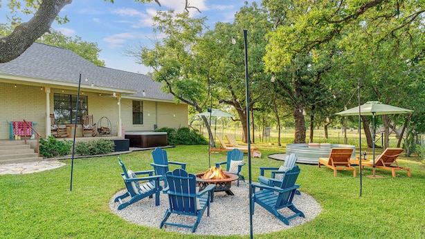 A backyard with a fire pit, outdoor furniture, and a house. - 290 Wine Trail, 2 Hot tubs, Cowboy Pool, Game Room (Fredericksburg)