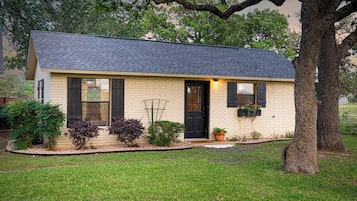 A single-story house with a dark roof, a front door, and a small porch area.