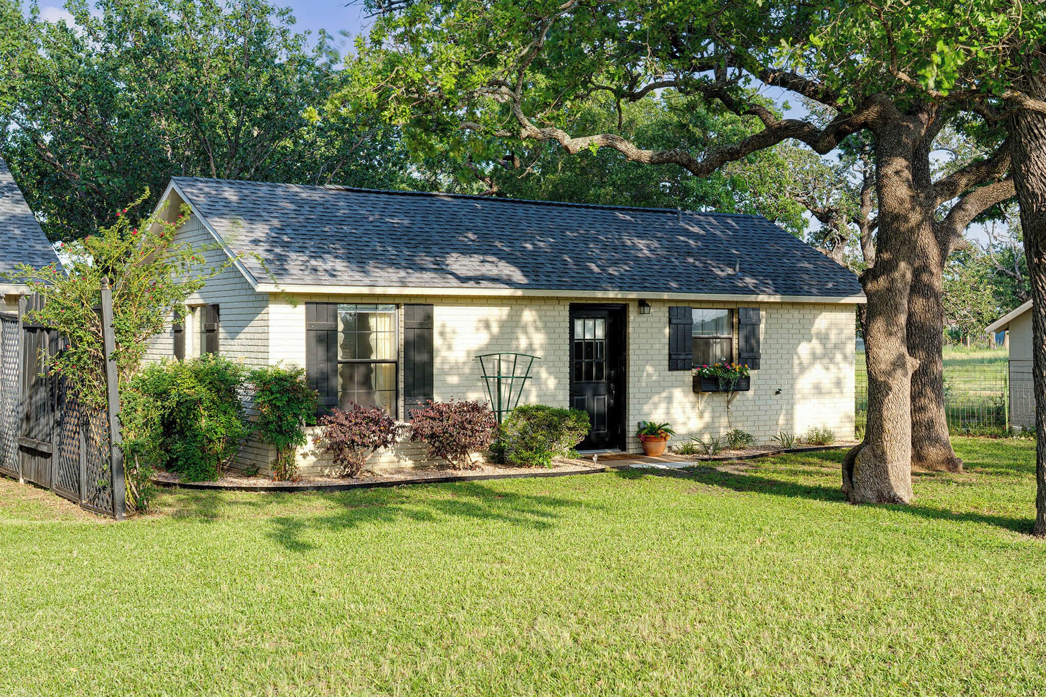 A single-story house with a sloped roof, a front porch, and a well-maintained lawn.