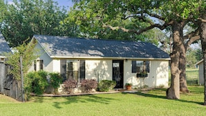 A single-story house with a sloped roof, a front porch, and a well-maintained lawn. - 290 Wine Trail, 2 Hot tubs, Cowboy Pool, Game Room (Fredericksburg)