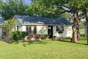 A single-story house with a sloped roof, a front porch, and a well-maintained lawn. - 290 Wine Trail, 2 Hot tubs, Cowboy Pool, Game Room (Fredericksburg)