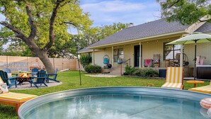 A backyard with a swimming pool, outdoor seating, and a house with a brick exterior. - 290 Wine Trail, 2 Hot tubs, Cowboy Pool, Game Room (Fredericksburg)