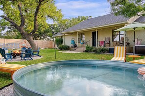 A backyard with a swimming pool, outdoor seating, and a house with a brick exterior. - 290 Wine Trail, 2 Hot tubs, Cowboy Pool, Game Room (Fredericksburg)