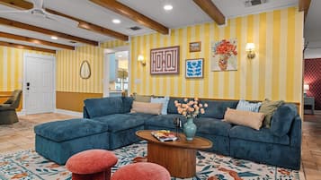 A living room with a sectional sofa, a wooden coffee table, and a patterned rug.