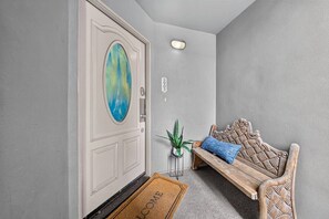 Ein modernes Interieur mit einer weißen Tür, einer Bank und einem Blumentopf.