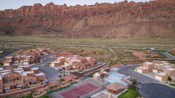 A residential area with modern buildings, a swimming pool, and a tennis court.