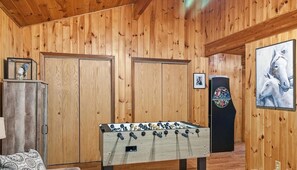 A room with wooden panel walls, a foosball table, a cabinet, and a framed picture. - Home with Hot Tub, Conveniently located between Boone and Blowing Rock, (Boone)