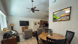 A living room with a sofa, TV, and a ceiling fan. - 4-BD/2-BA Southern Retreat with Waterfront Patio (Gainesville)